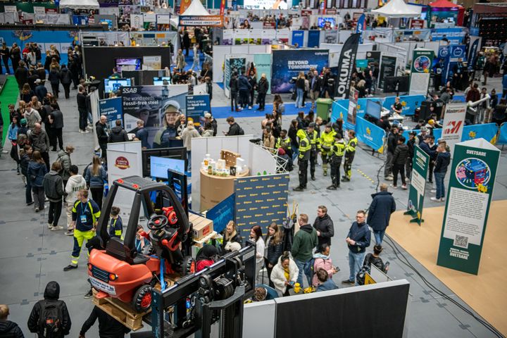 Översikt av mässa Yrkes-SM med utställningsmontrar och besökare.