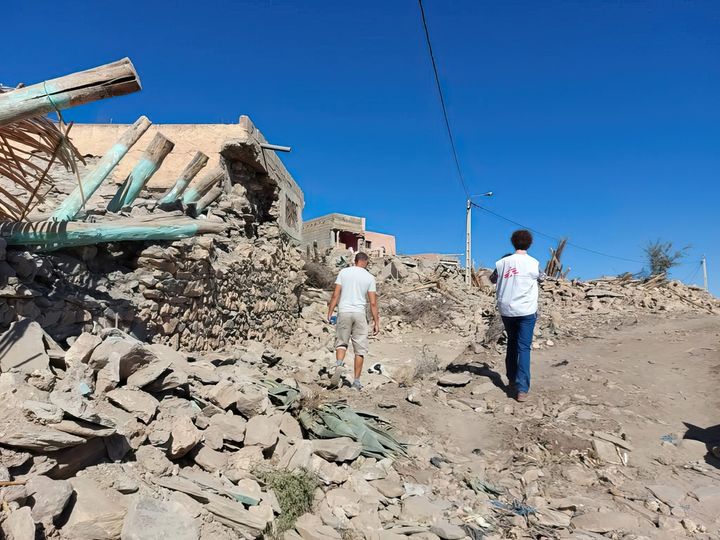 Två personer, bland dem en medarbetare från Läkare Utan Gränser, står vid ett rasat hus i Marocko som drabbades av en jordbävning den 8 september.