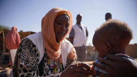 En medarbetare från Läkare Utan Gränser undersöker ett litet barn i Zamzam-lägret i norra Darfur, Sudan.