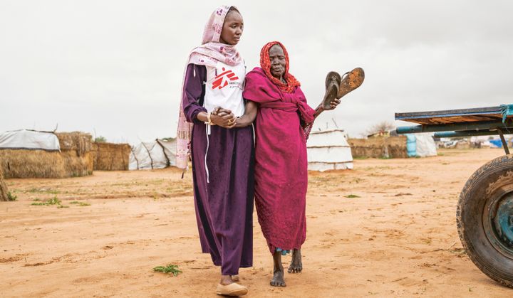 Aisha B, som arbetar som hälsoinformatör, hjälper 80-åriga Aisha G. till Läkare Utan Gränsers klinik i Adré transitläger i östra Tchad.