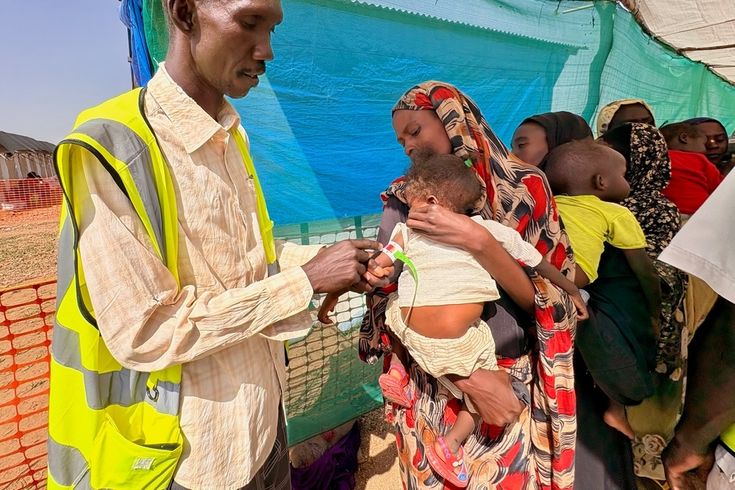 en man mäter omkretsen på ett litet barns överarm