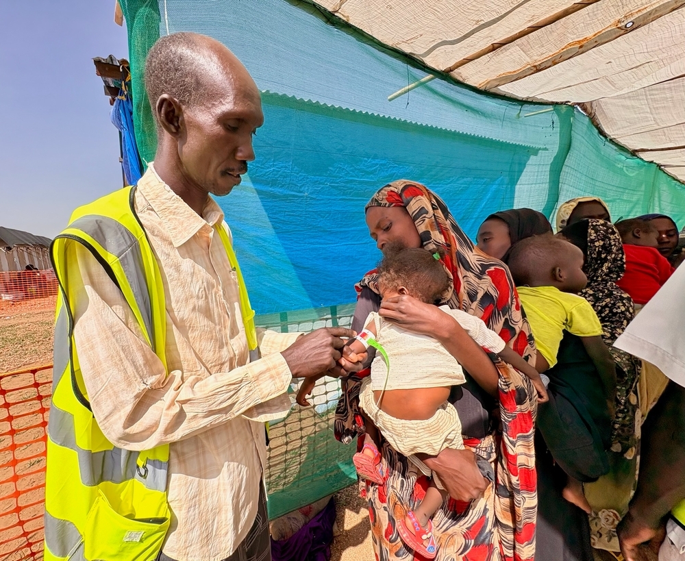 en man mäter omkretsen på ett litet barns överarm