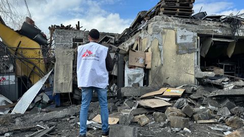 Läkare Utan Gränsers medarbetare Oleksandr Cherniavskyi står med ryggen mote kameran och ser över omfattningen efter en attack mot Läkare Utan Gränser i Pokrovsk, Ukraina, i april 2023.