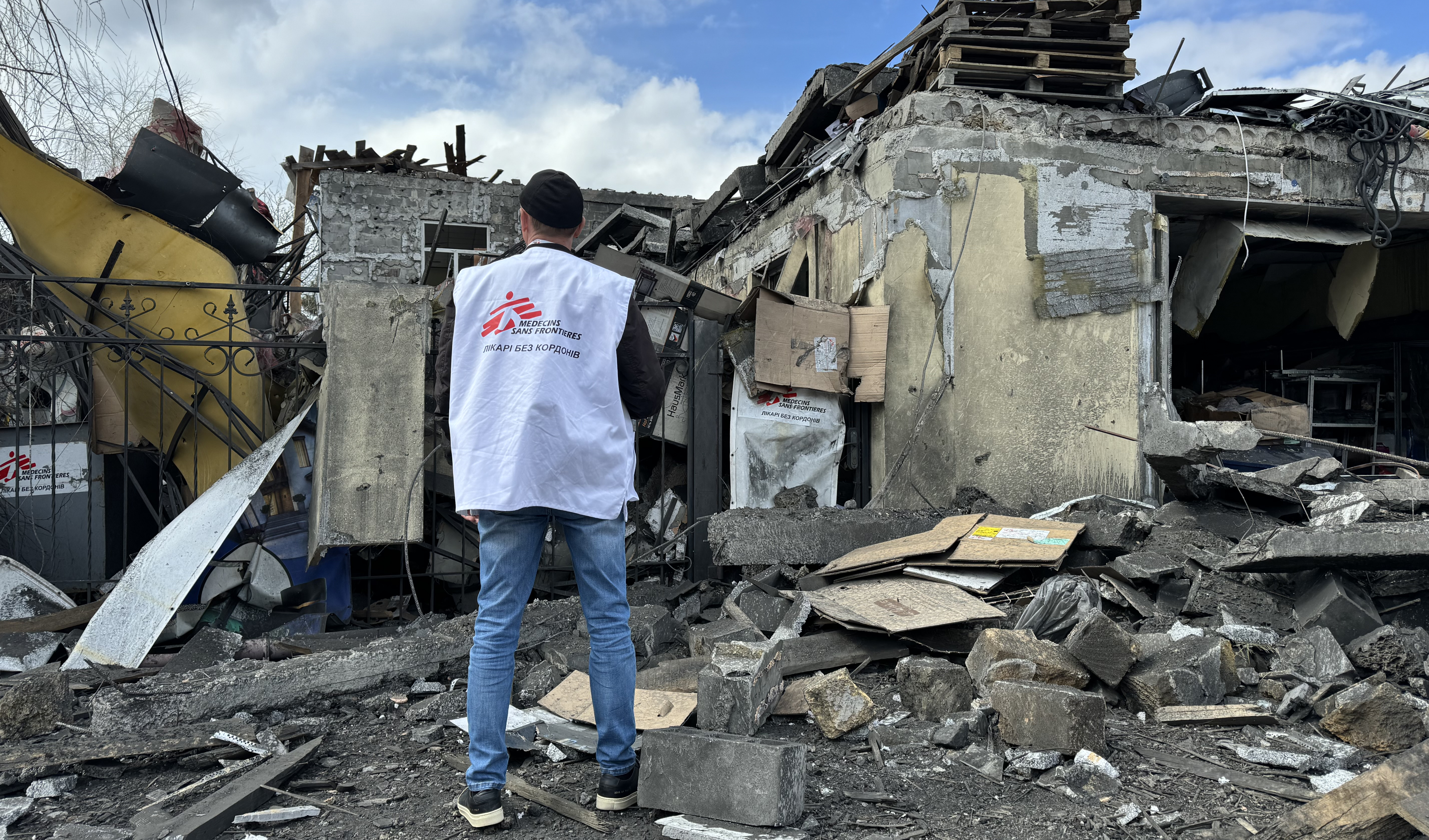 Läkare Utan Gränsers medarbetare Oleksandr Cherniavskyi står med ryggen mote kameran och ser över omfattningen efter en attack mot Läkare Utan Gränser i Pokrovsk, Ukraina, i april 2023.