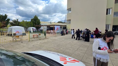 En mobil klinik från Läkare Utan Gränser i Saida, södra Libanon. En medarbetare står framför en bil. Bakom henne syns flera tält från Läkare Utan Gränser.