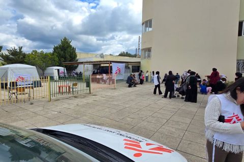 En mobil klinik från Läkare Utan Gränser i Saida, södra Libanon. En medarbetare står framför en bil. Bakom henne syns flera tält från Läkare Utan Gränser.