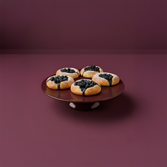 Fyra små blåbärskakor på ett mörkt fat.