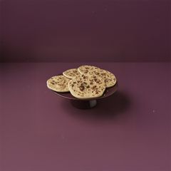 En tallrik med flera Gáhkku, ett traditionellt samiskt bröd, på ett lila bord.