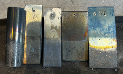 The corrosive effects of exposure to liquid lead can be seen on these sample bars of stainless steel.