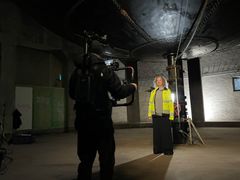 I den filmade julhälsningen har hovsångerskan Ann Hallenberg tagit sig högst upp i det gamla vattentornet på Djäkneberget, så hon står alldeles under vattenreservoaren.