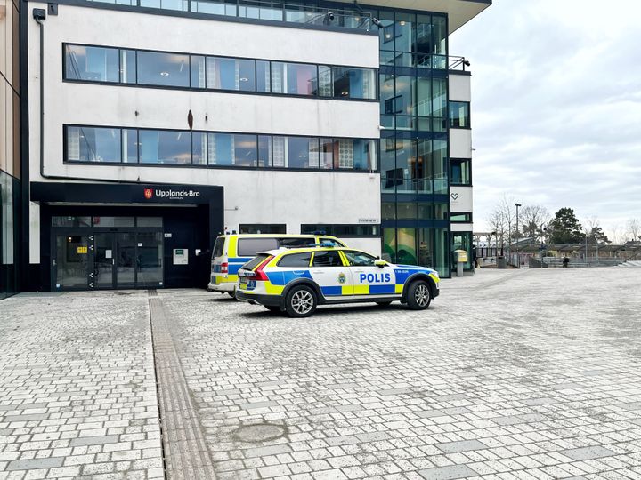Foto på en polisbil framför kommunhuset i Upplands-Bro