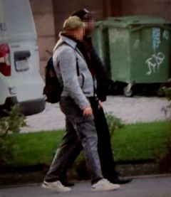 Två män promenerar sida vid sida i stadsmiljö.