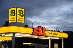 Gult, upplyst skärmtak på LBG-stationen i Jordbro. Det är kväll och en röd logotype St1 och ett B för biogas lyser på skärmtaket.
