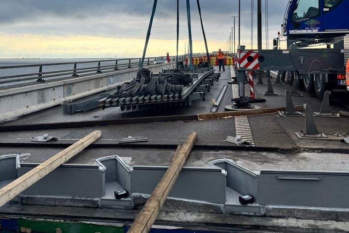 Arbete%20p%E5%20%D8resundsbron%20med%20utbyte%20av%20en%20expansionsfog.%20En%20kran%20lyfter%20fogen%20medan%20arbetare%20st%E5r%20i%20n%E4rheten%20p%E5%20bron.