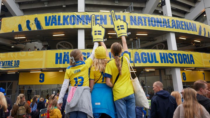 Tre barn som står utanför Nationalarenan Gamla Ullevi iklädda gulblåa färger.