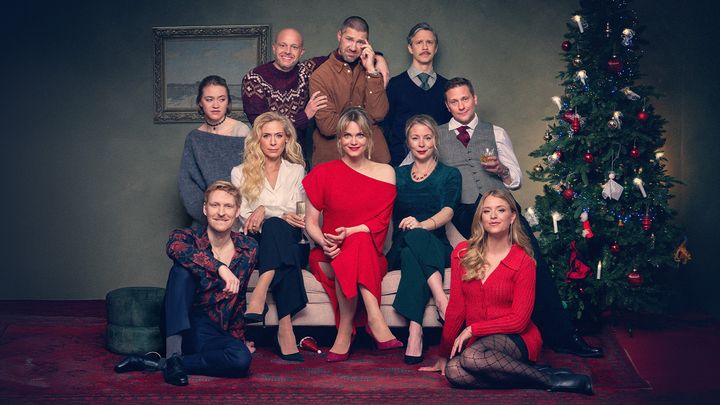 Ensamblen till Tomten är far till alla barn sittandes i en soffa.