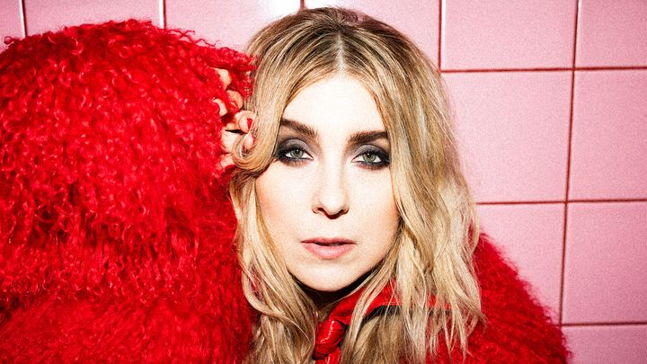 Miss Li mot en rosa kakelvägg.