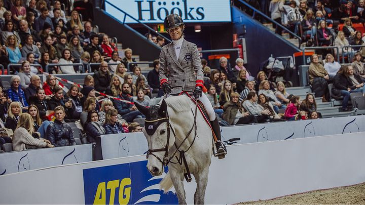 Kvinna rider på en vit häst under Göteborg Horse Show 2018.