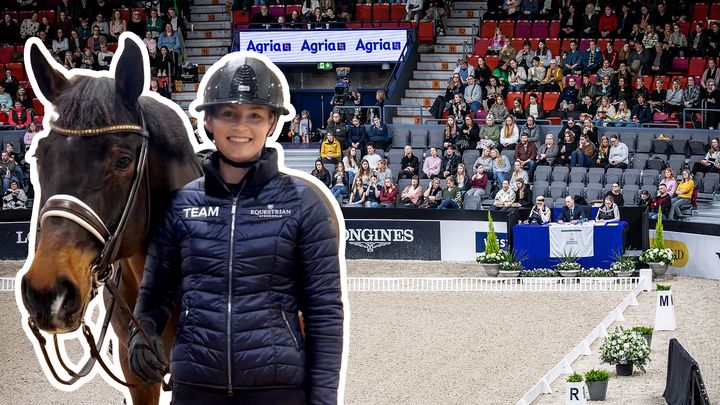 Kvinna står bredvid en häst på en inomhusarena.