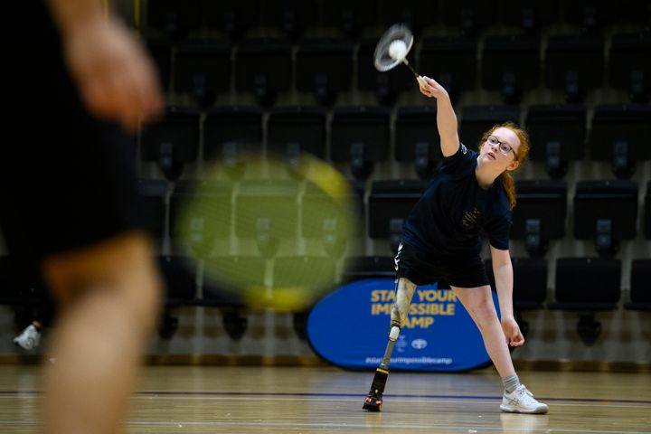 Flicka med benprotes spelar tennis