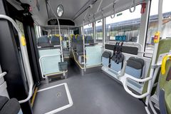 Interiör av en tom buss med sittplatser och säkerhetsbälten.