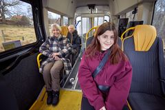 En liten buss med tre passagerare, en ung kvinna, en äldre kvinna och en äldre man.