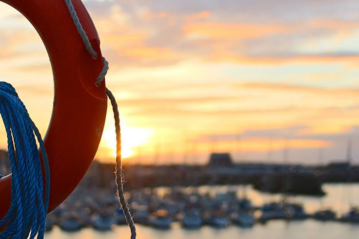 Livboj med en hamn i solnedgång i bakgrunden.