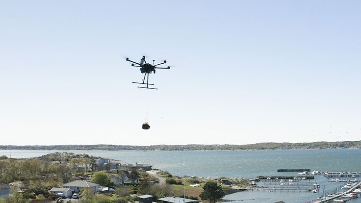 Drönare som åker i luften över en hamn en fin sommardag.