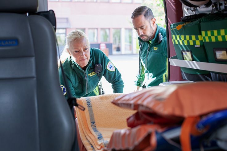 Ambulanspersonal som lastar ur en ambulandsbil på redskap.