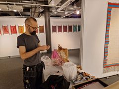 Konstnären förbereder konstverk inför vernissage.