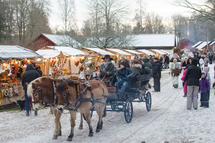Gammaldags julmarknad med häst och vagn, snöklädda väg och marknadsstånd i Hallstahammar.