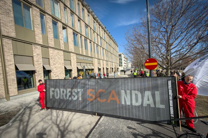 Aktivister protesterar utanför SCA:s årsstämma med en stor banderoll som säger "Forest Scandal".