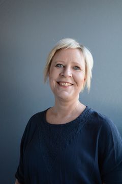 Paulina Lindgren är fotad i halvkroppsbild mot en grå bakgrund