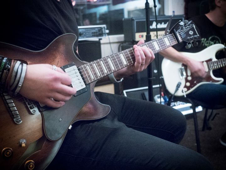 Två personer som spelar gitarr