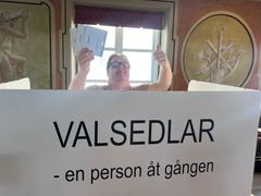 Tommy Svensson visar upp valsedlar under inspelningen av musikvideon till låten Alla får rösta.