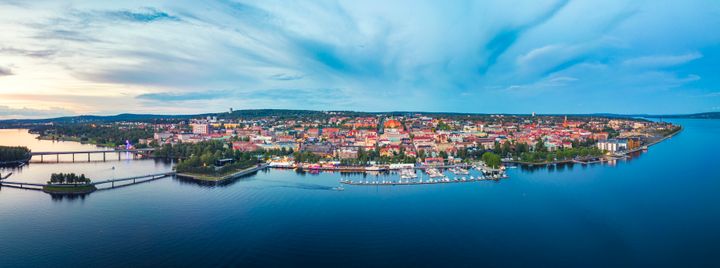 Fågelvy över ett somrigt Östersund med centrala staden, hamnen, vattnet och broarna till Frösön.