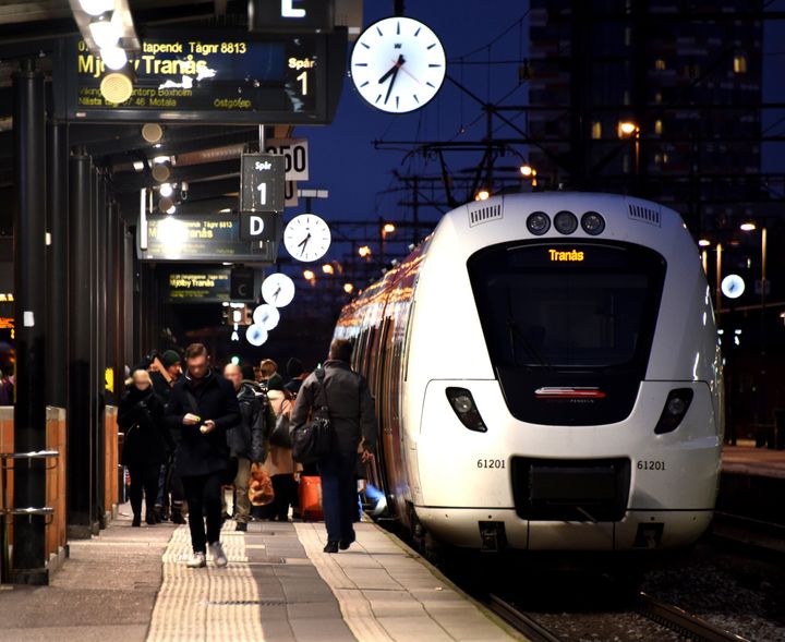 Östgötapendeln på stationen i Linköping och en massa personer på väg att gå på och av.