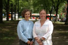 Två personer med bussar i bakgrunden