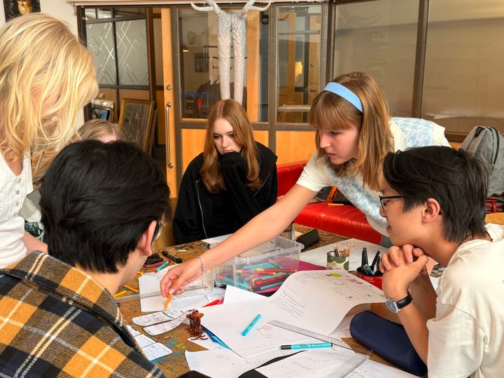 Unga arbetar i grupp med idéer och skisser för kollektivtrafiken