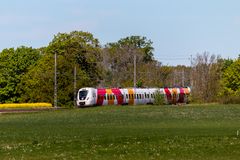 Östgötapendeln intill ett fält.