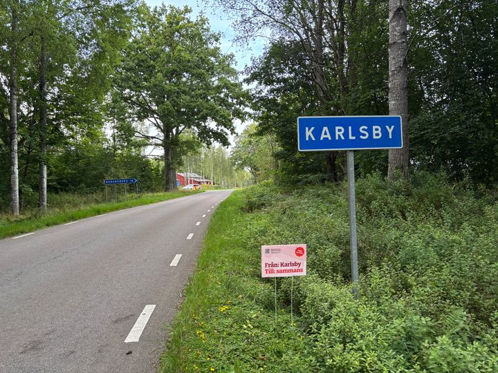 Vägskylt som det står Karlsby på och reklamskylt för att resa tillsaammans.