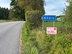 Vägskylt med texten Nykil och en reklamskylt om att resa tillsammans