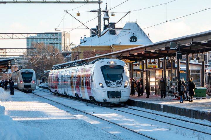 Två Östgötapendlar inne på Linköpings station. Människor är på väg att gå på.