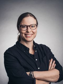Kvinna med glasögon ooch armarna i kors