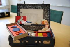 En portfölj med ett äldre test som användes för att bedöma utvecklingen hos små barn. I portföljen finns bland annat klossar, en bok, en bil och en docka.