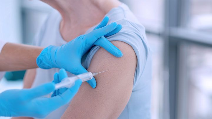 En person får vaccin i armen.