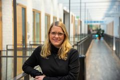 Frida Harvey lutad mot räcke i en korridor