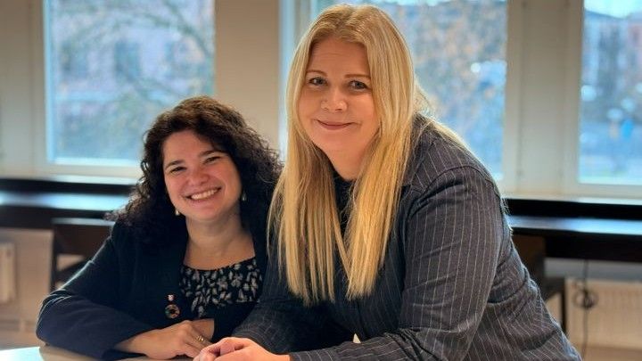 Två forskare framför ett fönster