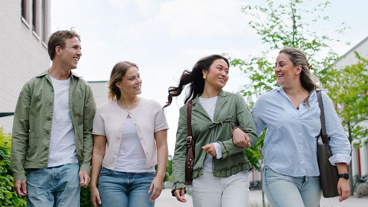 Fyra studenter går på campus.