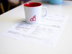 En kaffekopp ovanpå ett papper som är en hyresavi.